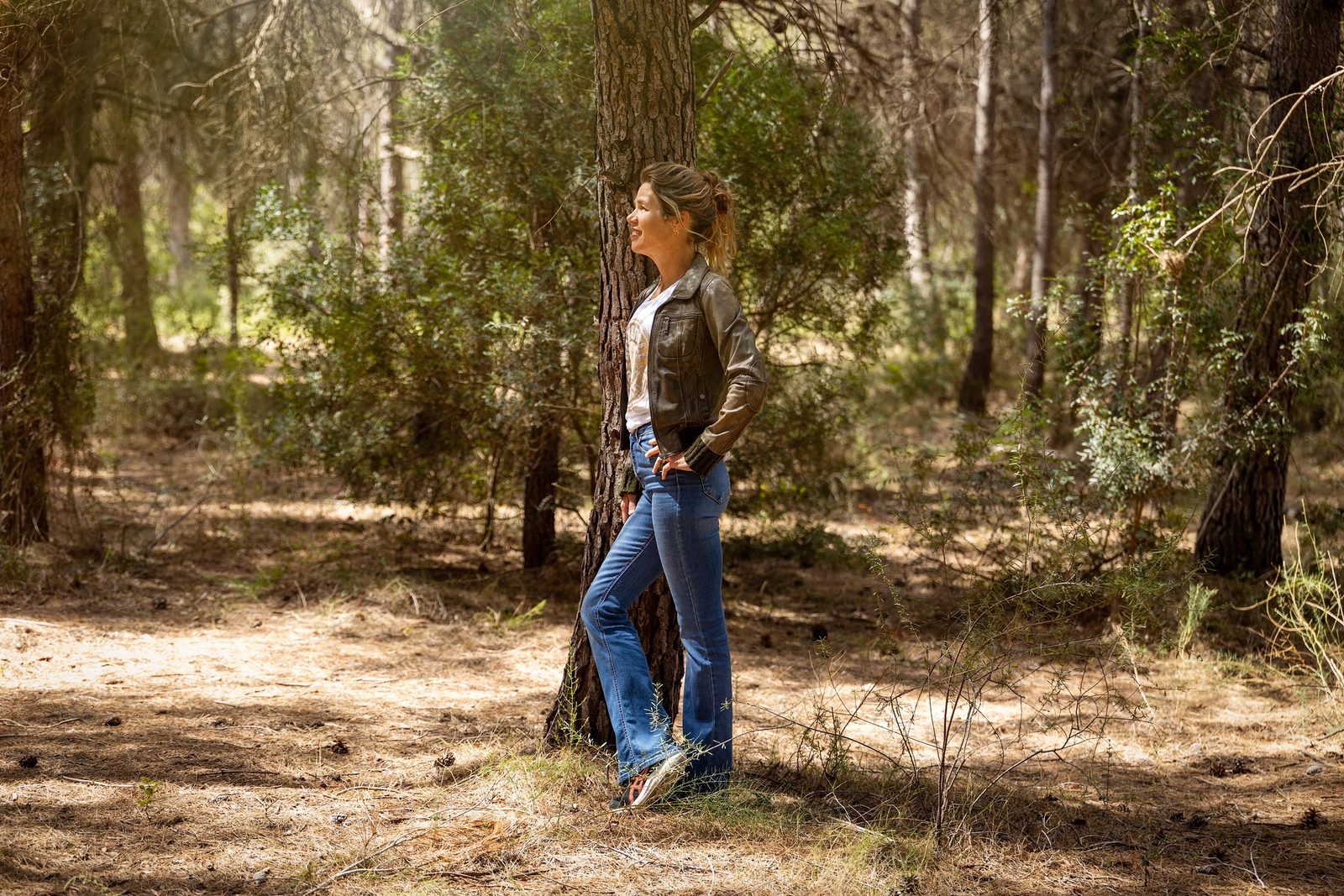 Suzan Grootscholten leaning against a pine tree in the forest near Cura